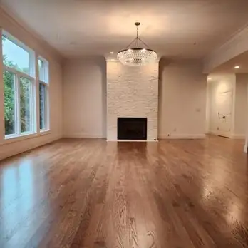 Wood flooring in an empty room with a fireplace