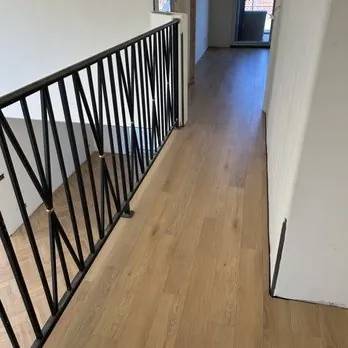 Wood-look plank flooring beside a hallway railing